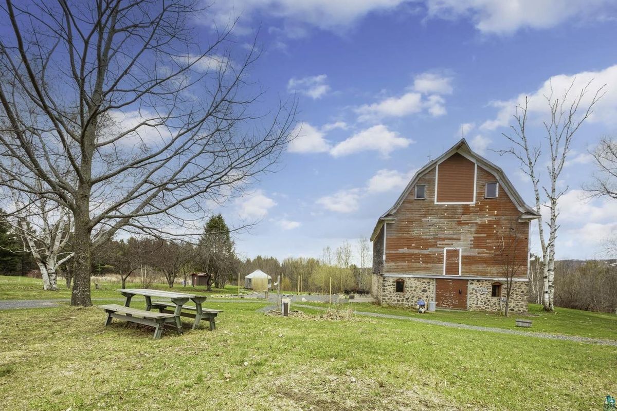 Picnic tables on the lawn beside the barn, with the yurt in the distance.